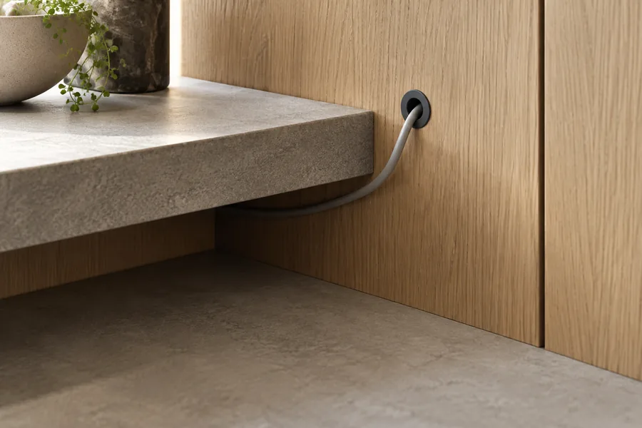 Illustrative cable exit through a cabinet back panel beside a fixed shelf.