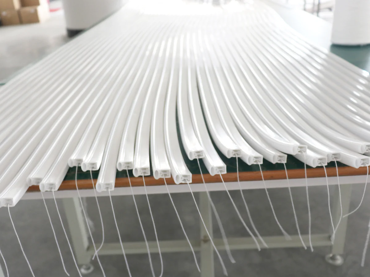 Rows of extruded white silicone profiles with their end cross-sections visible