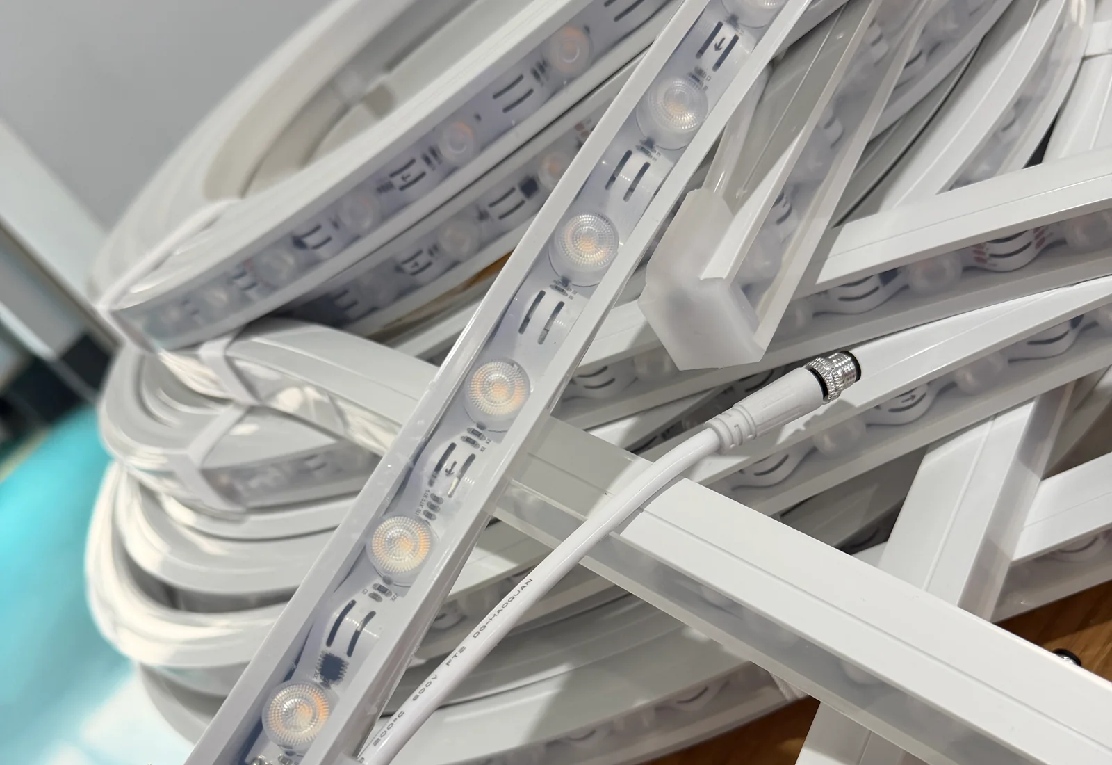 Actual LED strip in white lighting profiles with a cable connector visible among supplied assemblies