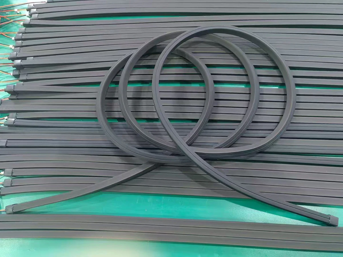 Flexible neon lighting assemblies arranged in curved forms on a production surface