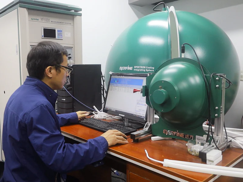 Technician reviewing LED lighting measurements with an integrating sphere system