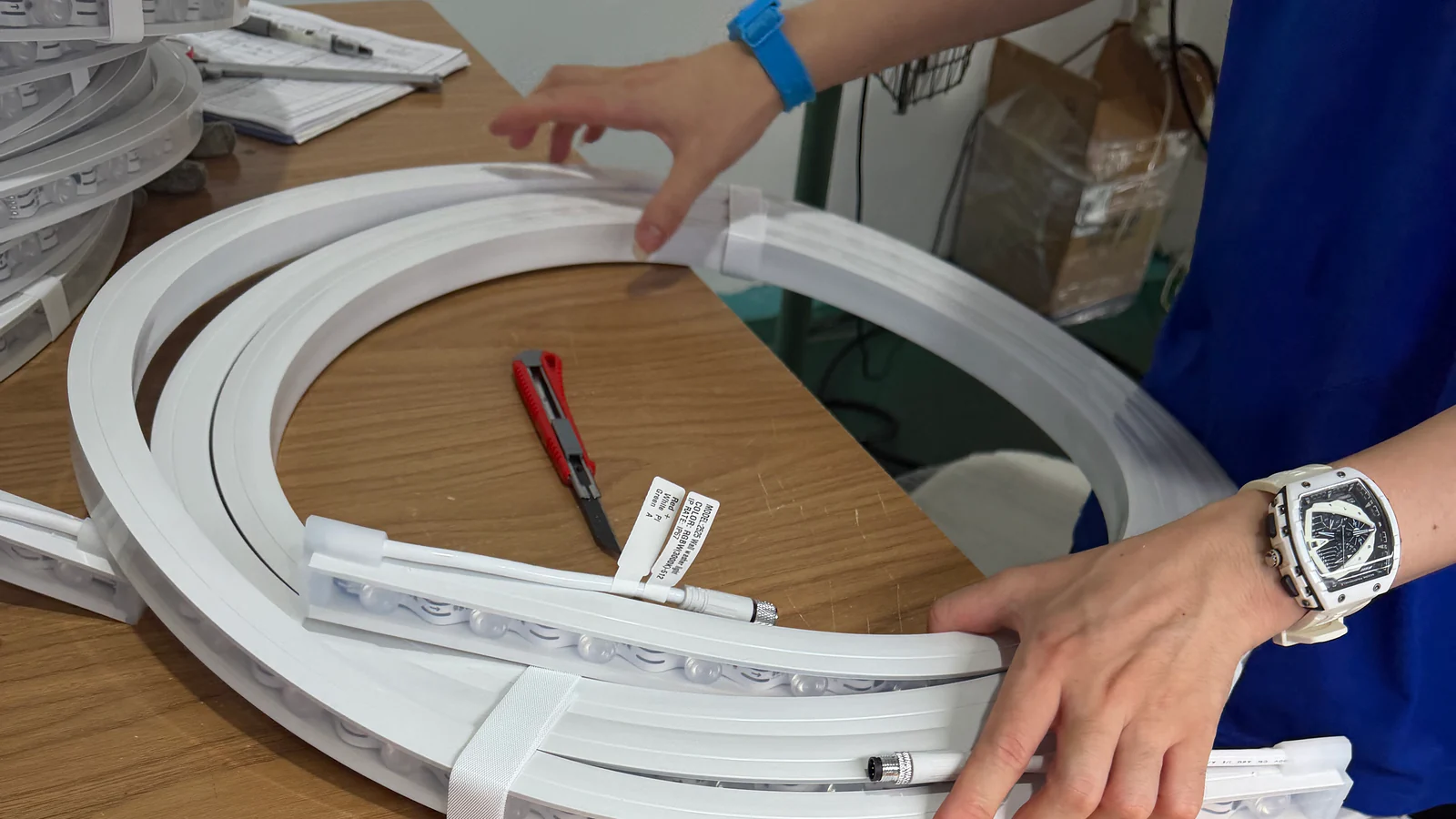 Flexible white silicone lighting profiles being handled on an assembly workbench