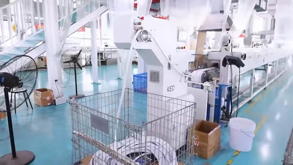 Factory footage follows silicone profile output from processing equipment into a collection basket.